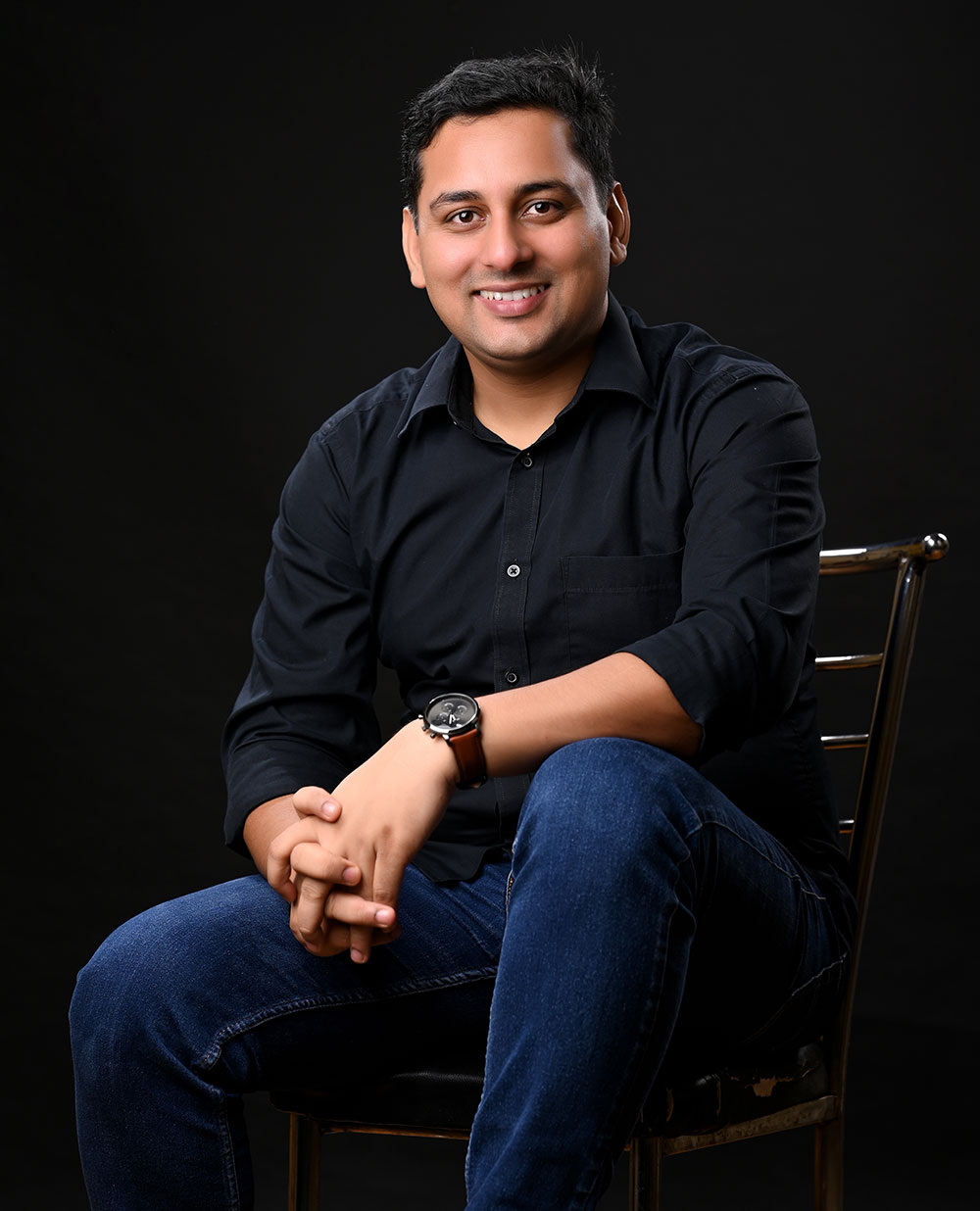 best mindset coach certified mindset Coach Rajendra in a black shirt, wearing a wristwatch, against dark background, radiating motivation