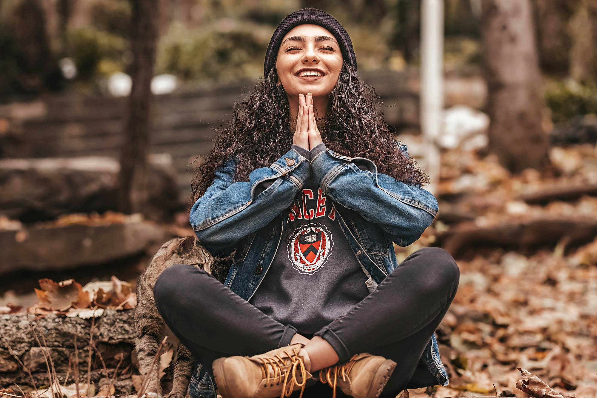 Smiling woman sitting cross-legged, practicing mindfulness, symbolizing inner peace and balance. Free webinar Mastering Work Life Balance